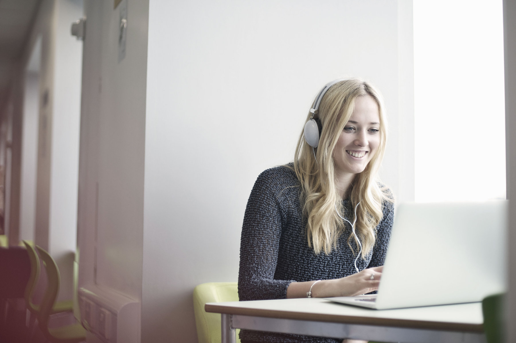 Woman smiling while using a laptop