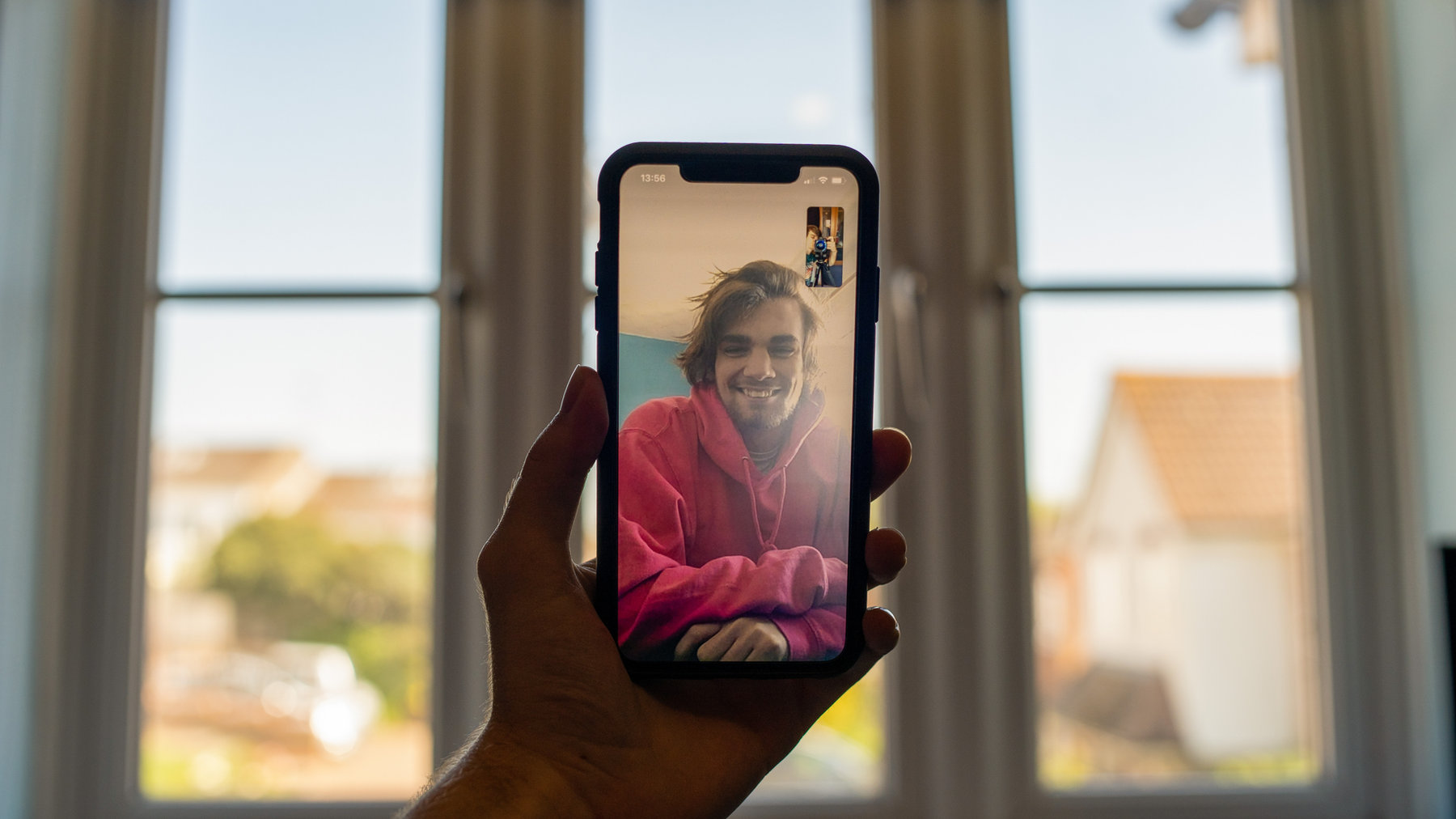 Hand holding a phone during a video call